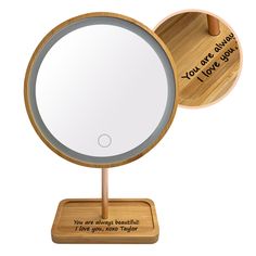 a wooden stand with a round mirror on it's side and an engraved message