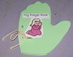 a green book shaped like a hand with a drawing of a woman on it and the words, my prayer book