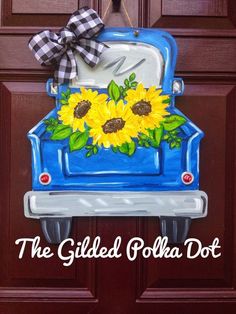 a blue truck with sunflowers painted on it's side and the words, the gilded polka dot