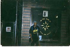 a man standing in front of a building with a compass on it's wall