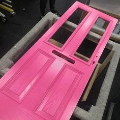 a pink door is being painted in the process of being installed to a bench or table