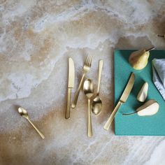 gold utensils and pears on a marble table