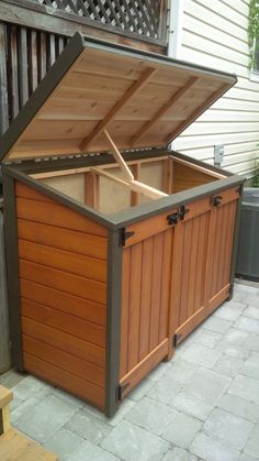 a large wooden storage box sitting on top of a patio