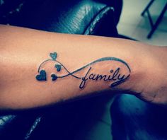 a woman's arm with a tattoo on it that says family and two hearts