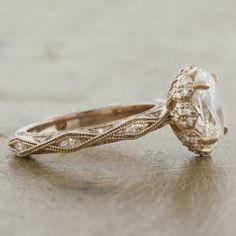 an antique style diamond engagement ring on a table