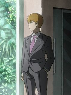 a man in a suit and tie standing next to a door with his hands on his hips