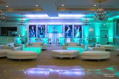 a room filled with lots of white couches and chairs in front of green lights