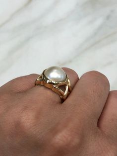 https://www.youtube.com/watch?v=LmsKK0XX-NQ Displayed is a contemporary Mabe pearl and gold solitaire ring. The natural center stone has a beautiful cream color and impressive size. The pearl measures an exact 14.0mm x 14.0mm and is breathtaking. Steadily put, the mabe pearl is held in a secure 14K yellow gold bezel creating a modern and sleek look. To further its beauty, the ring is accented by marvelous gold work that resembles bamboo or a complex structure. The ring is ideal for everyday use Unique 14k Yellow Gold Pearl Ring, Luxury 14k Gold Pearl Ring With Polished Finish, Luxury 14k Gold Pearl Ring, Timeless 14k Gold Jewelry With High Luster, 14k White Gold Rings With High Luster, Luxury 14k Gold Hallmarked Pearl Ring, Luxury Hallmarked 14k Gold Pearl Ring, Luxury White Ring Stamped 14k, Luxury White 14k Stamped Diamond Rings