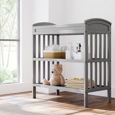 a baby crib with a teddy bear on the bottom shelf