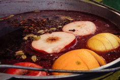 apples and oranges are being cooked in a pot