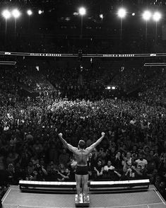 a man standing on top of a tennis court holding his arms up in the air