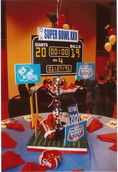 a table topped with a cake covered in football memorabilia and balloons on top of it