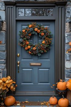 a blue front door decorated with wreaths and pumpkins