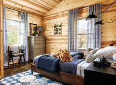 a dog laying on top of a bed in a room with wooden walls and ceiling