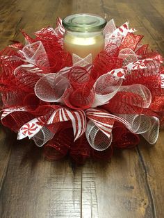 a red and white mesh wreath with a candle