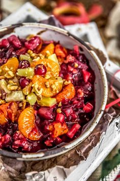 a bowl filled with fruit and nuts on top of a table