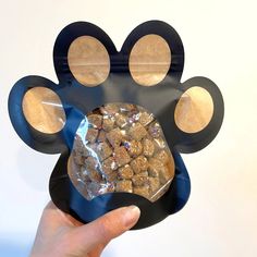 a person holding up a dog's paw shaped treat