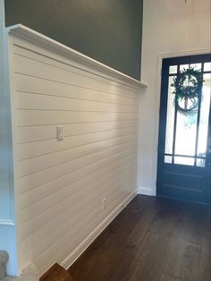 an empty entryway with a wreath on the wall