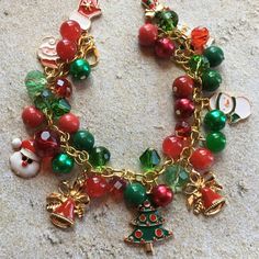 This Christmas charm bracelet is approx. 7.5 inches long and surrounded by green and red glass beads and holiday charms. #17 Christmas Green Beaded Bracelets, Green Christmas Festive Bracelets, Green Beaded Bracelets For Christmas, Handmade Green Bracelets For Holiday, Green Bracelet Jewelry For Holiday, Holiday Green Beaded Bracelets, Green Beaded Bracelets For Holiday, Red Christmas Festive Bracelets, Red Christmas Bracelets For The Holidays