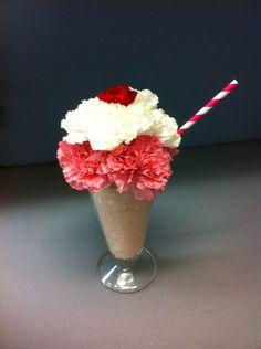 a vase filled with flowers and two straws