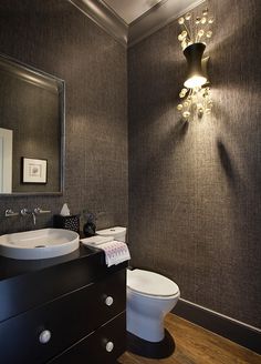 a white toilet sitting next to a bathroom sink