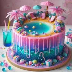 there is a colorful cake with umbrellas and candy on the table next to it