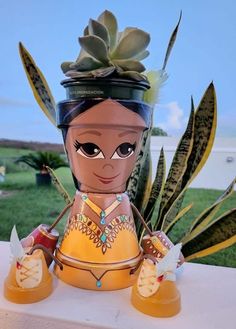 a ceramic figurine sitting on top of a white table next to some plants