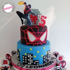 a spiderman themed birthday cake with cupcakes