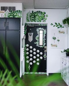 an open door to a room with plants on the wall and green foliage painted on it