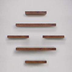 four wooden shelves are arranged on the wall