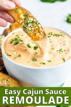 a hand dipping a piece of bread into a bowl of homemade remoulade