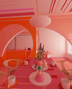 a room with pink and orange walls, white furniture and flowers in vases on the table