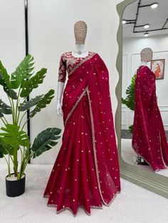 Elevate your ethnic wardrobe with this stunning Red Shimmery Organza Designer Saree, crafted to perfection for the modern woman who appreciates traditional charm with a touch of glamour. This exquisite saree features a rich organza fabric that drapes beautifully and shimmers in the light, making it a standout piece for any special occasion. The saree is adorned with delicate golden embellishments along the border, enhancing the vibrant red color with an elegant finish. The ready-made blouse comes with intricate golden embroidery and can be easily customized to achieve a tailored fit, ensuring you feel both comfortable and glamorous. adding an extra layer of elegance to the timeless red color. complete with a beautifully embellished ready-made golden blouse that offers easy customization to Transitional Bollywood Style Chinon Blouse Piece, Festive Transitional Chinon Blouse, Red Georgette Blouse For Eid, Bollywood Style Chinon Blouse For Diwali, Red Saree With Mirror Work For Celebration, Red Saree With Mirror Work For Eid, Red Blouse With Resham Embroidery For Celebration, Chinon Blouse Piece With Mirror Work For Celebrations, Red Blouse Piece With Mirror Work For Eid