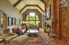 a living room filled with furniture and a fire place in the middle of an open floor plan