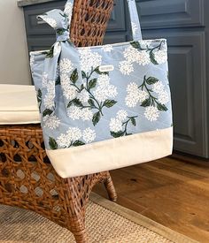 Beautiful Quilted Hydrangea Tote Bag made with cotton fabric by Rifle Paper Co., and lined in a natural cotton canvas. This medium/large tote measures approximately 16" wide x 14.5" tall, with a 3.5" inch boxed base.  The straps add approximately 11" to the overall length.  The two interior pockets measure 5.5" wide by 8" deep. Laundering:  Spot treat or gentle wash, air dry and light iron as necessary. *Handmade matching bag scarf is included, and can be removed. Summer Cream Cotton Canvas Bag, Blue Fabric Bags For Spring, Blue Fabric Bag For Spring, Spring Blue Fabric Bag, Cream Cotton Shoulder Bag For Summer, Cotton Bucket Shoulder Bag For Daily Use, Spring Beige Cotton Beach Bag, Beige Cotton Shoulder Bag For Spring, Spring Cream Tote Canvas Bag