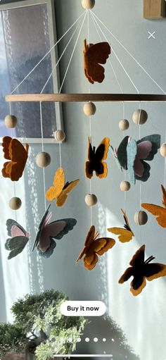 a mobile with butterflies hanging from it's sides and the words buy it now