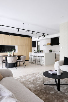 a living room filled with furniture next to a kitchen