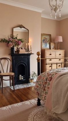 a bed room with a neatly made bed next to a fire place and a chandelier