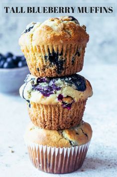 three muffins stacked on top of each other with blueberries in the background