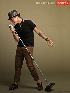 a man with a hat and cane is holding a microphone in one hand while standing on the other