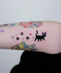 a woman's arm with a cat and flowers tattoo on the left side of her arm