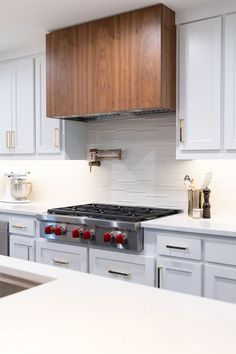 a stove top oven sitting inside of a kitchen next to white counter tops and cabinets