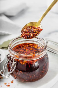 homemade chinese chili oil in a glass jar with a spoon full of it and the text overlay reads easy homemade chinese chili oil