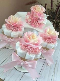 pink flowers are placed on top of white cake with pink bows and pearls around the edges