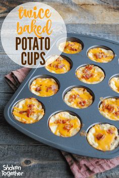 mini baked potato cups with bacon and cheese in a muffin tin on a wooden table