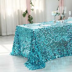 a table covered in blue sequins and candles