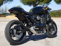 a black motorcycle parked on top of a parking lot