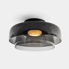 a black and white ceiling light with a circular glass shade on the top of it