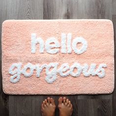 someone is standing on the floor in front of a pink rug that says, hello gorgeous