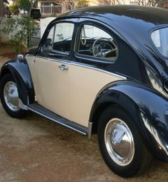 an old black and white beetle parked in front of a house